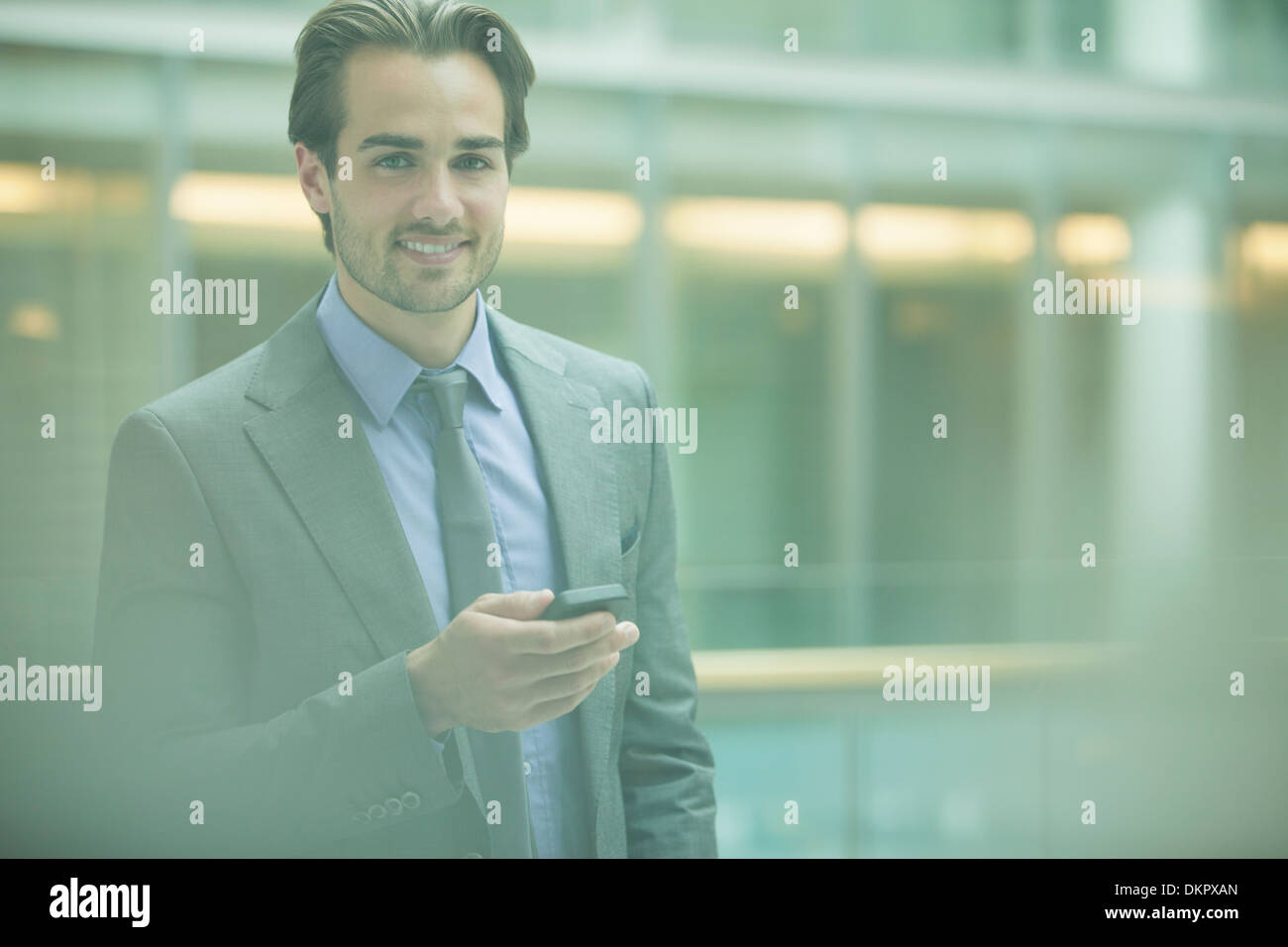 Businessman using cell phone in office Banque D'Images