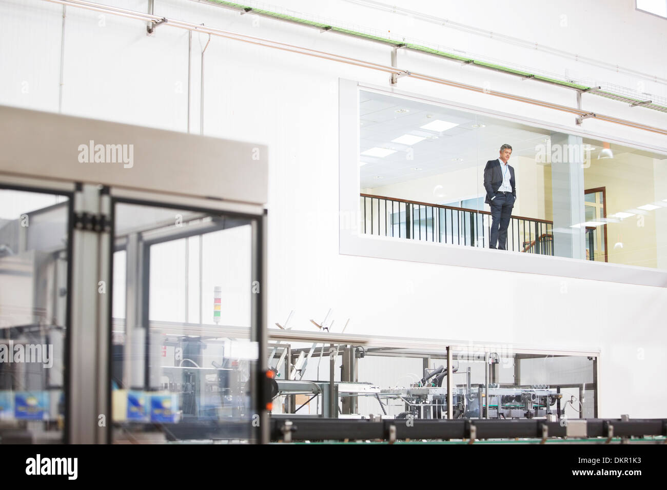 Businessman in fenêtre donnant sur factory Banque D'Images