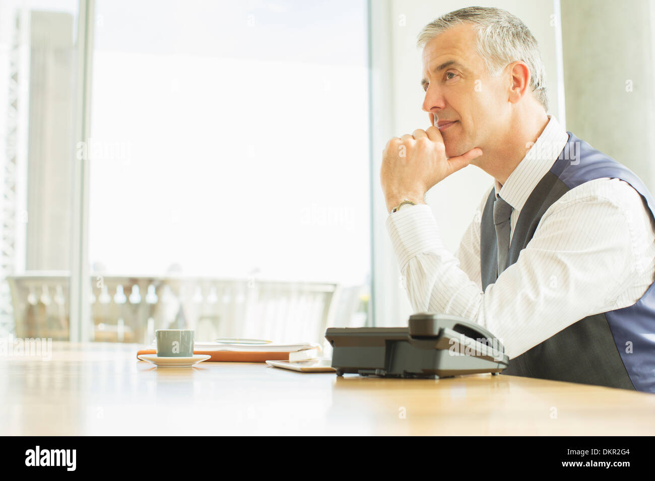 Businessman sitting at desk in office Banque D'Images