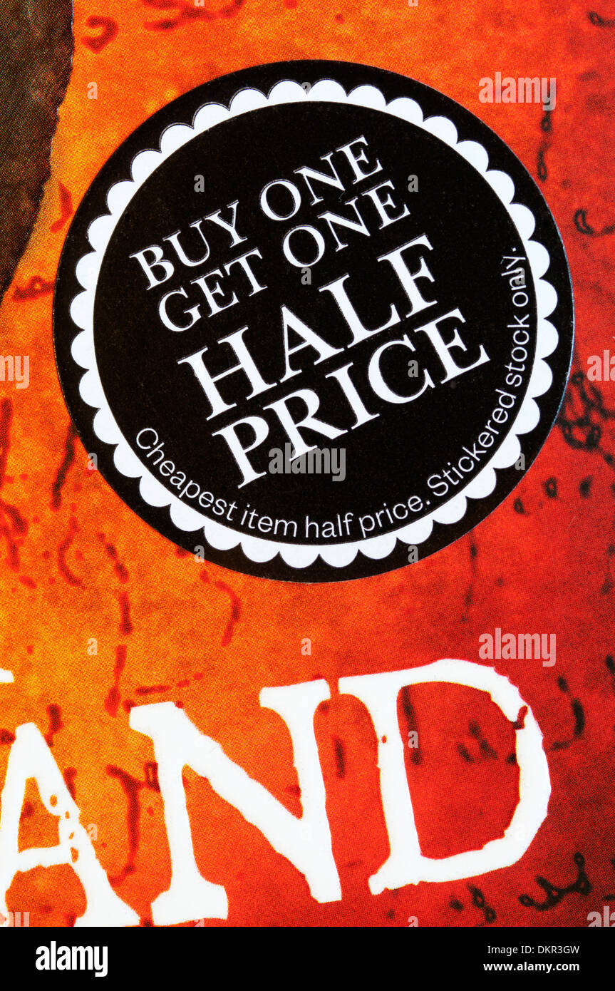 L'achat Un obtiennent un autocollant à moitié prix sur la couverture d'un livre dans une librairie. Banque D'Images