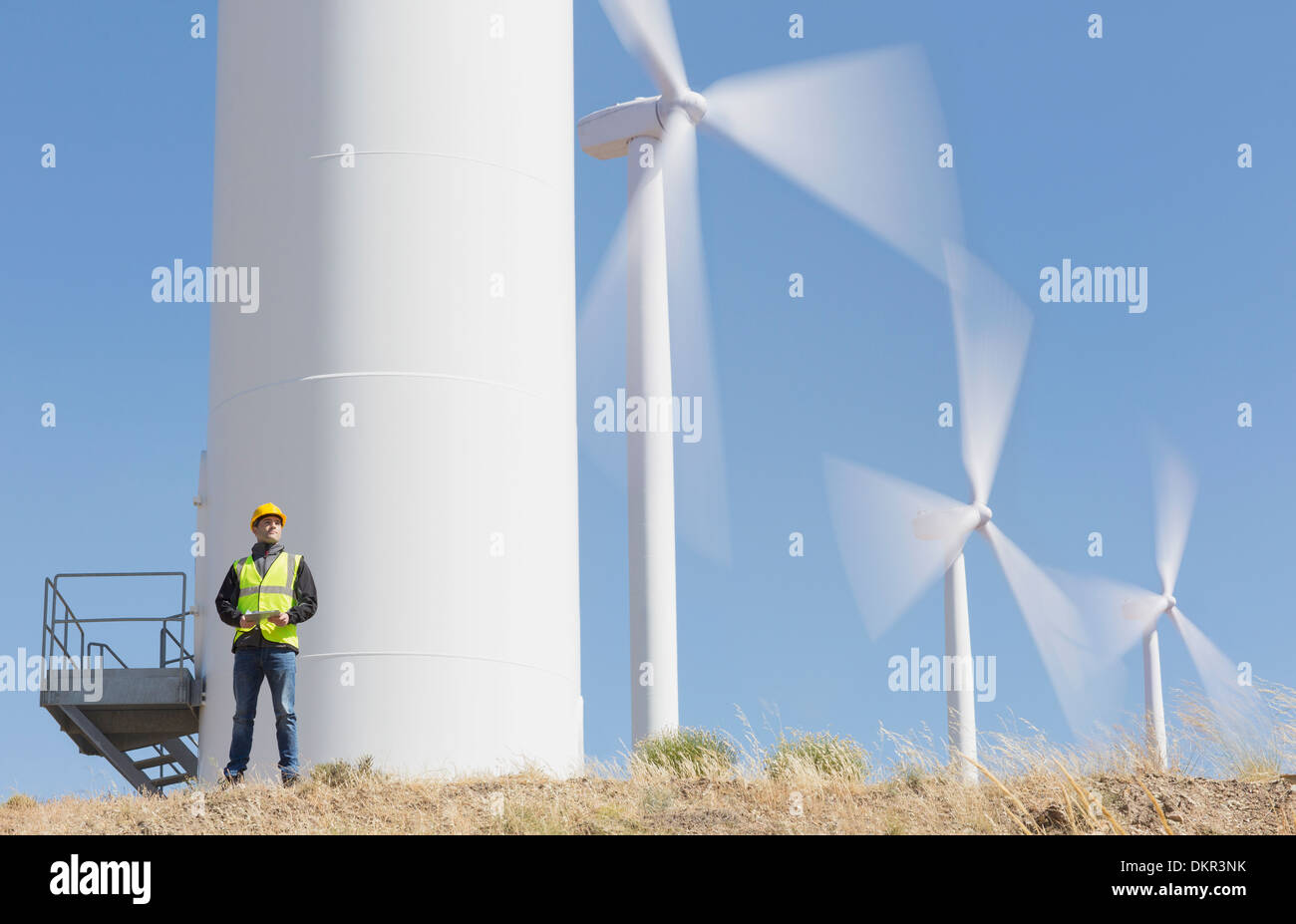 Travailleur par les éoliennes dans le paysage rural Banque D'Images