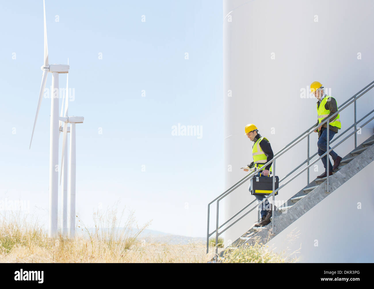 Les travailleurs sur wind turbine in rural landscape Banque D'Images