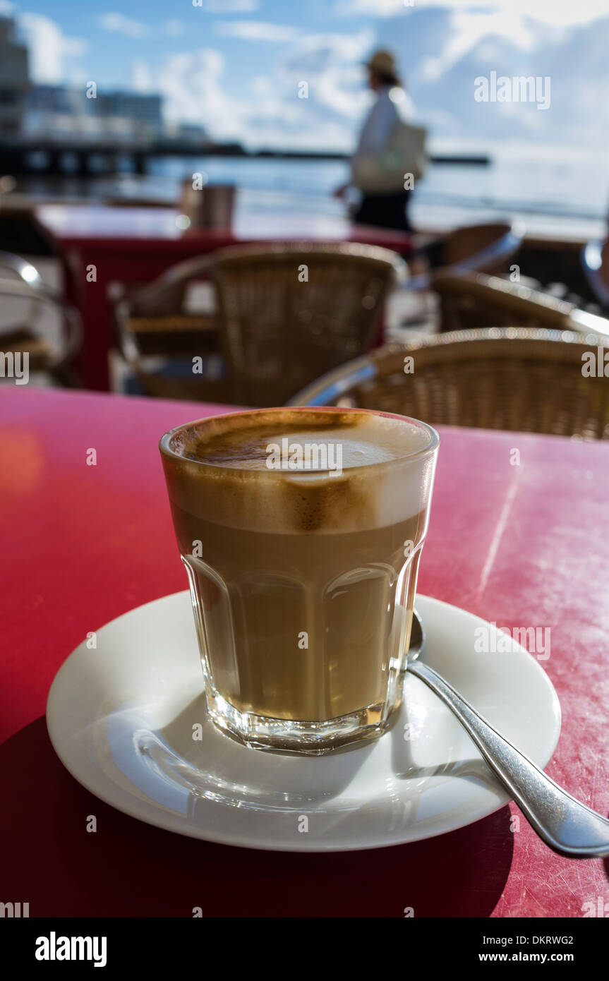 Cafe con leche dans un verre à une terrasse extérieure cafe à El Medano, Tenerife, Canaries, Espagne. Banque D'Images
