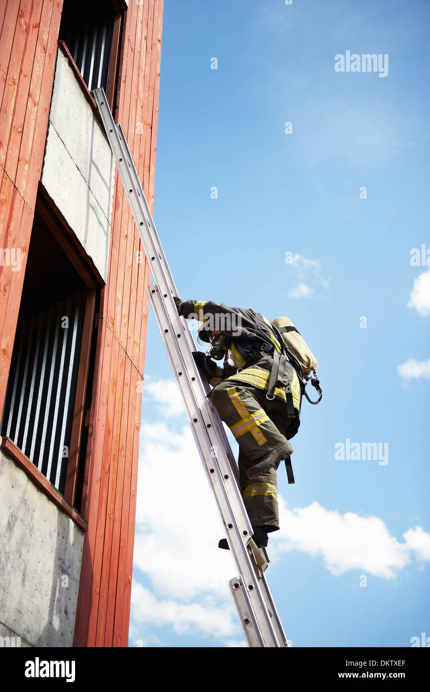 Grimper sur les escaliers d'incendie pompier à la fenêtre Banque D'Images