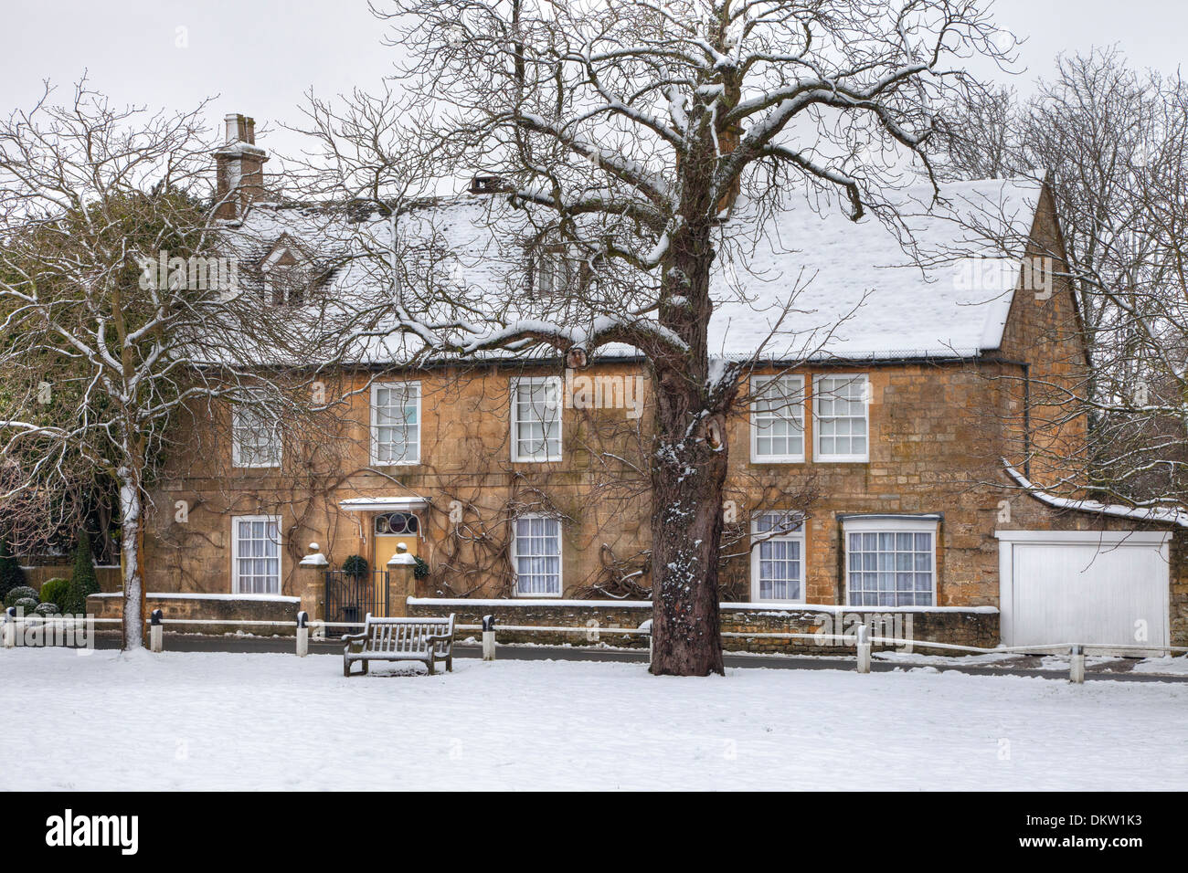La neige a couvert propriété de caractère surplombant le village green, Broadway, Worcestershire, Angleterre. Banque D'Images