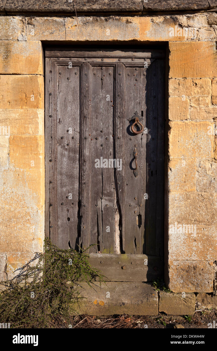 Cotswold en bois ensemble de porte en mur de pierre, Gloucestershire, Angleterre. Banque D'Images