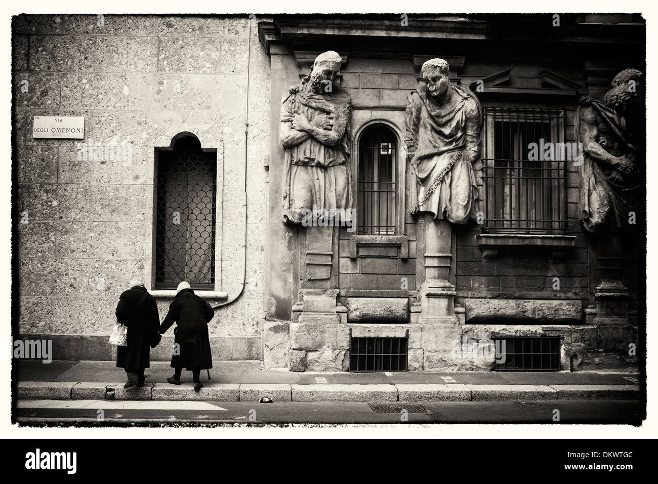 Un couple de personnes âgées passe devant la Casa degli Omenoni à Milan, Italie. Banque D'Images