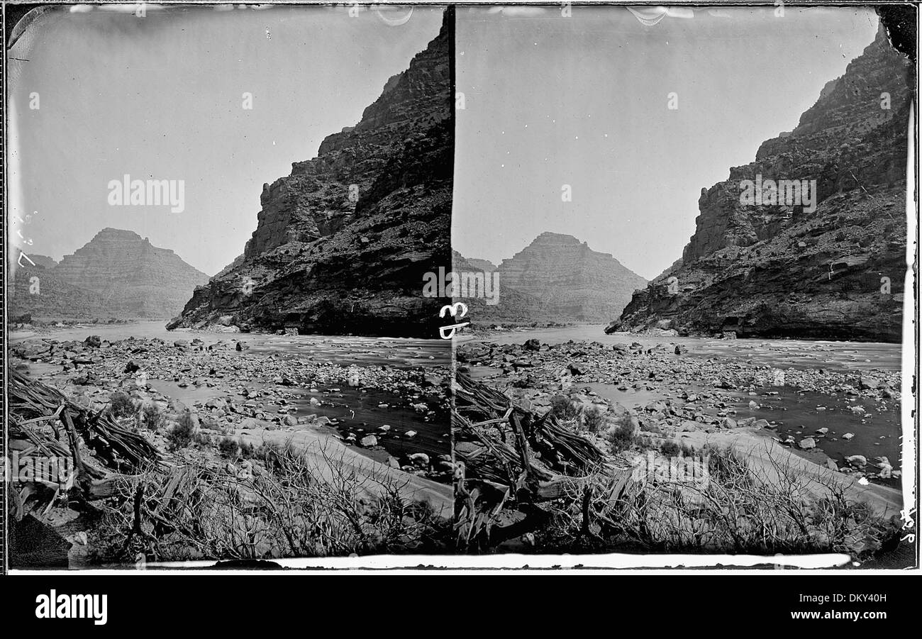 La rivière Green coule à travers le Canyon de la désolation, où les vestiges d'une ancienne clôture et de marqueurs numérotés (344, 362, 756) peuvent être vus au premier plan. Cet emplacement fait partie de la nature sauvage accidentée, offrant des vues spectaculaires et un environnement naturel isolé. Banque D'Images