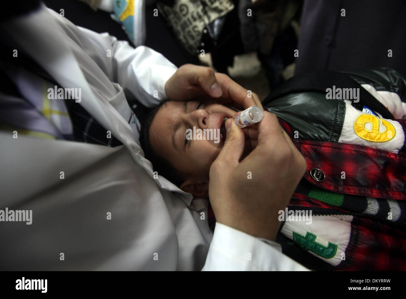Gaza, Territoires Palestiniens, . 9Th Mar, 2013. Un agent de santé palestinien administre le vaccin contre la poliomyélite chute à un enfant pendant cinq jours d'une campagne anti-polio, à Gaza le 09 décembre 2013. Le ministre de la santé dans la bande de Gaza, Mufid al-Mokhalalaty, a dit dimanche que son ministère commenceront une campagne anti-polio de vacciner 300 000 enfants en ligne avec le plan de l'Organisation mondiale de la santé d'arrêter une épidémie de polio en l'an 2015.Photo : Moemen Faiz/NurPhoto NurPhoto © Moemen Faiz/ZUMAPRESS.com/Alamy/Live News Banque D'Images