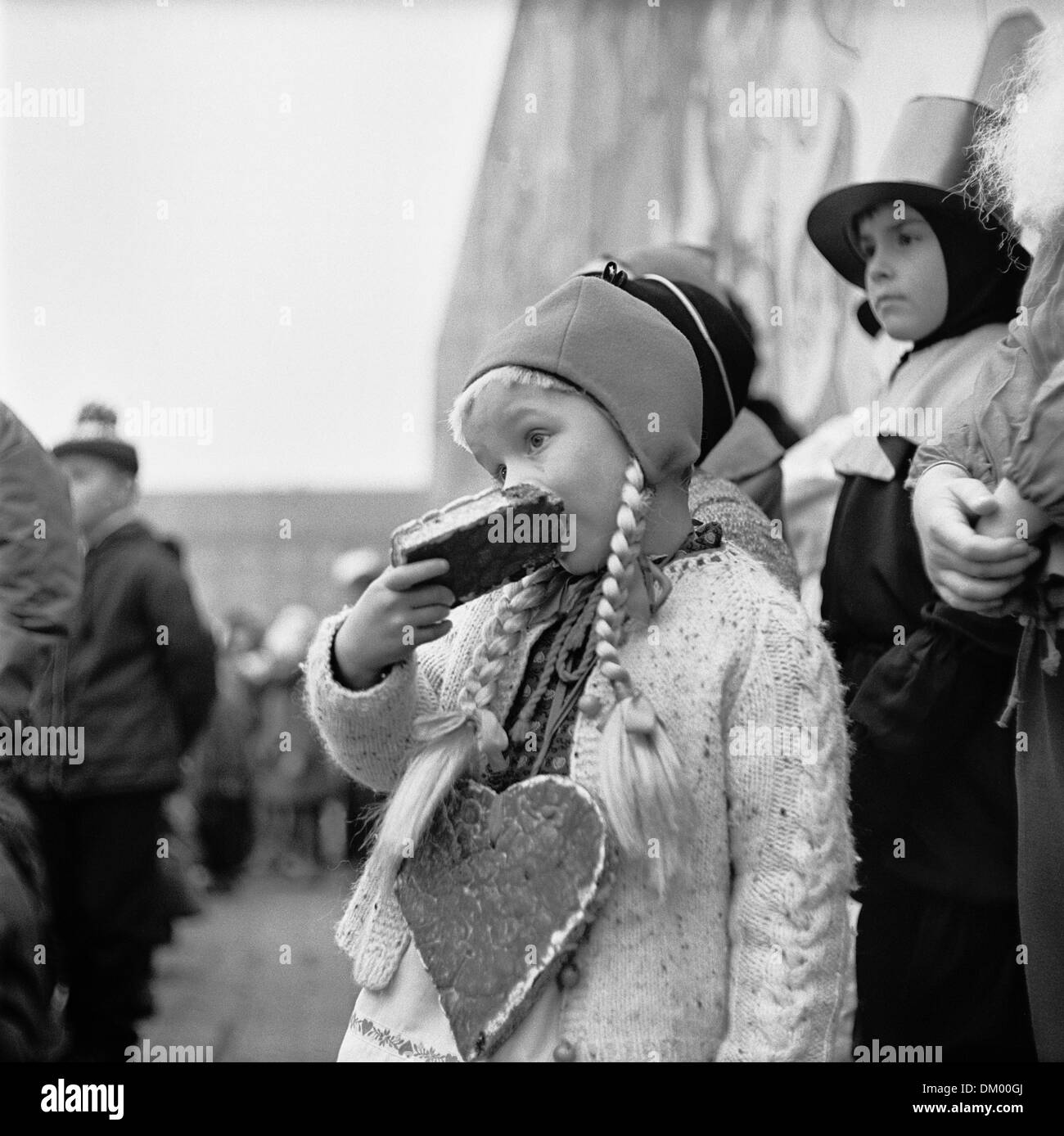 Une petite fille mange le pain d'épice sur le Striezelmarkt à Dresde, Allemagne, sans date photo (décembre 1968). Photo : Deutsche Fotothek/Erich Höhne, Erich Pohl Banque D'Images