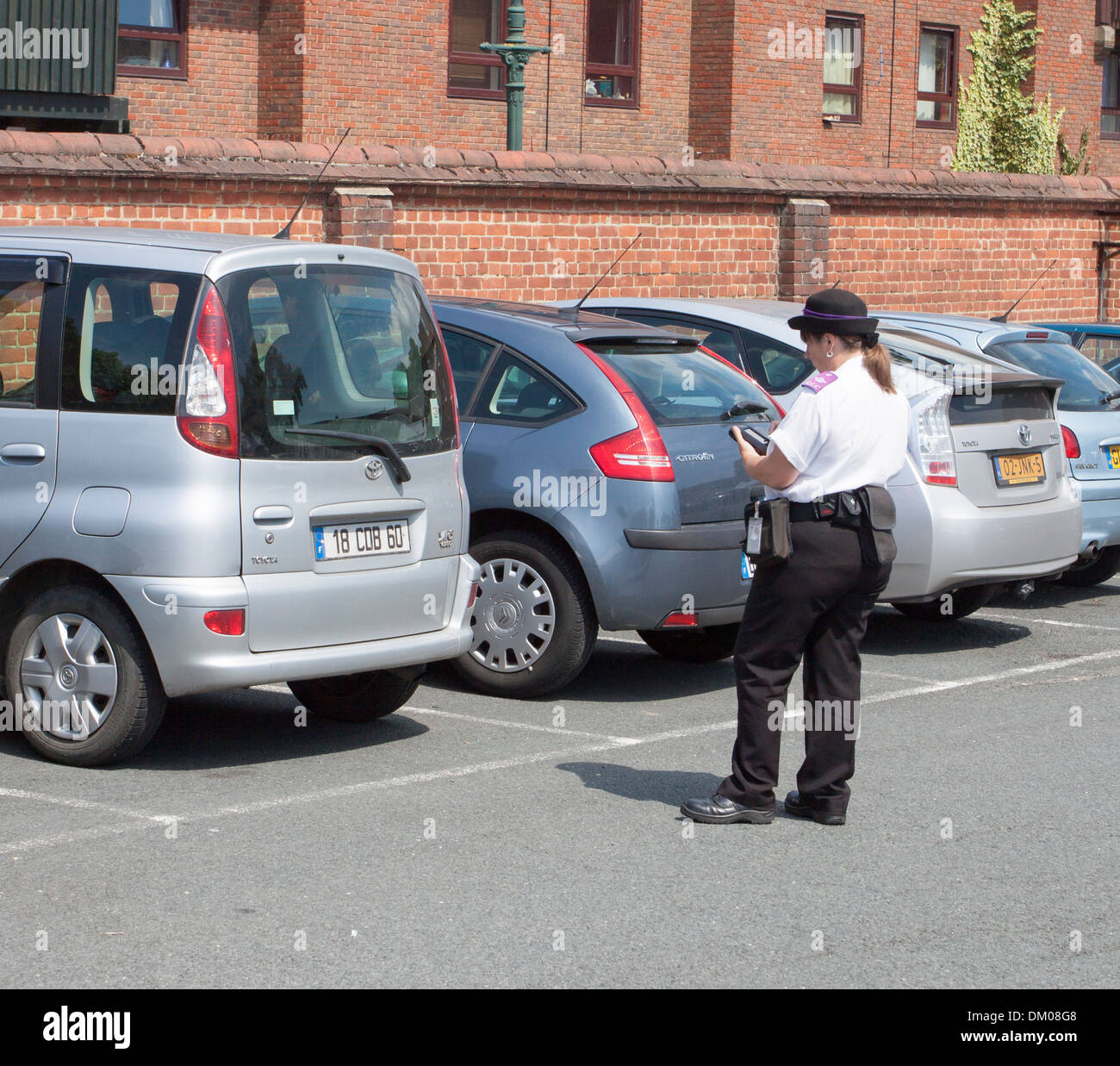 Directeur de trafic l'émission d'un billet de stationnement pour visiteurs étrangers voiture à Canterbury en Angleterre Banque D'Images