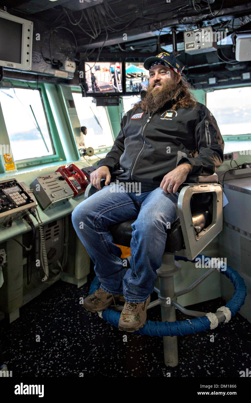 Dynastie des canards de la télé-réalité star Willie Robertson est assis dans le fauteuil du commandant au cours d'une visite du pont à bord de la classe Arleigh Burke destroyer lance-missiles USS Stout 7 décembre 2013 dans la baie de Souda, la Grèce. La visite de Robertson fait partie de l'assemblée annuelle de l'USO tour pour aider à stimuler le moral des militaires déployés outre-mer. Banque D'Images