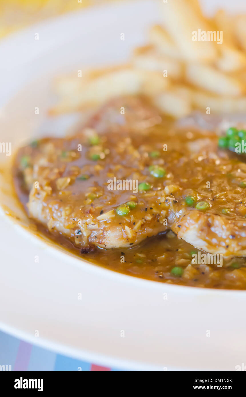 Close up Pavé de boeuf, sauce au poivre vert servi avec pommes frites et légumes Banque D'Images