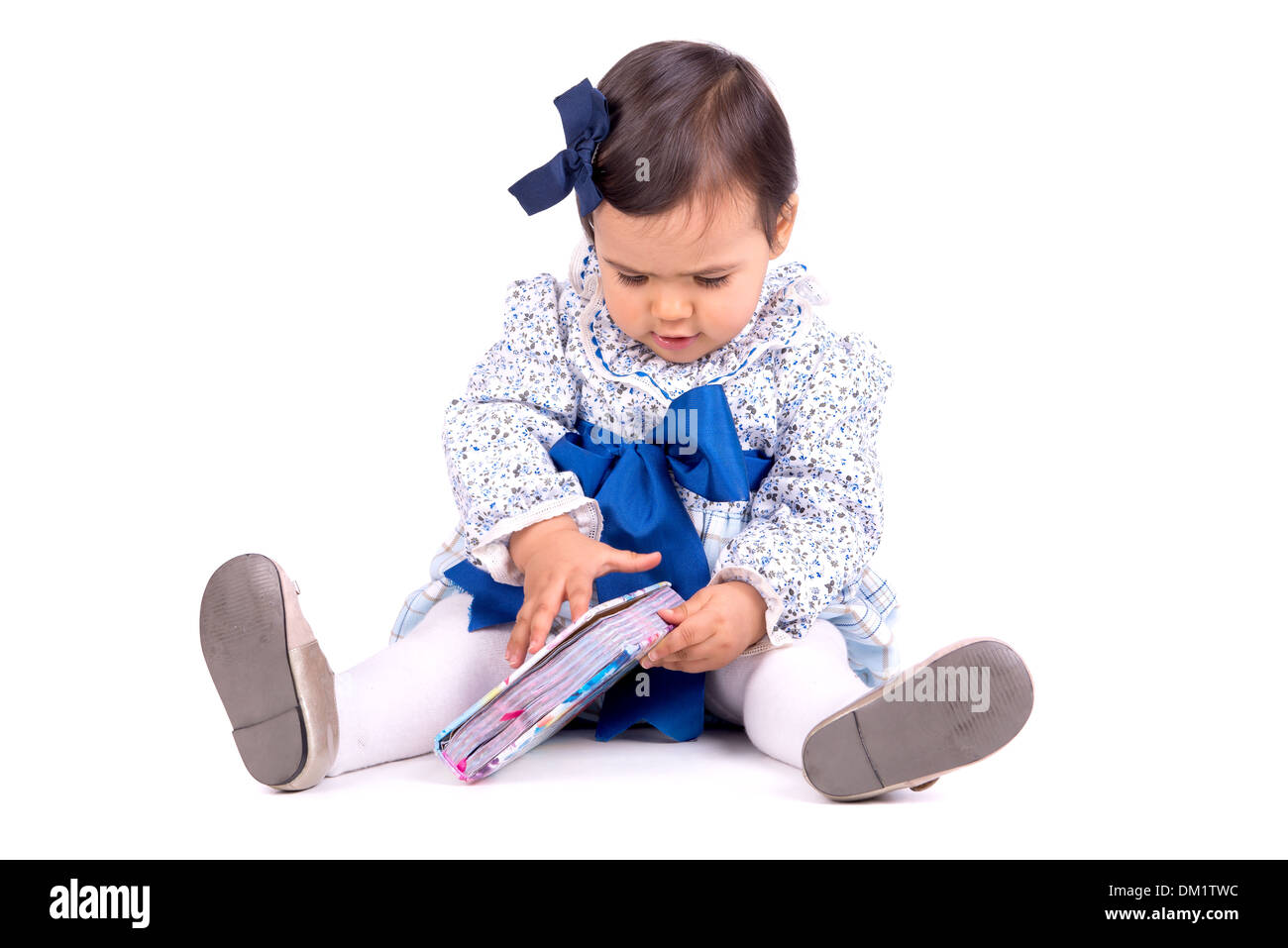 Sweet baby girl Playing with a book Banque D'Images