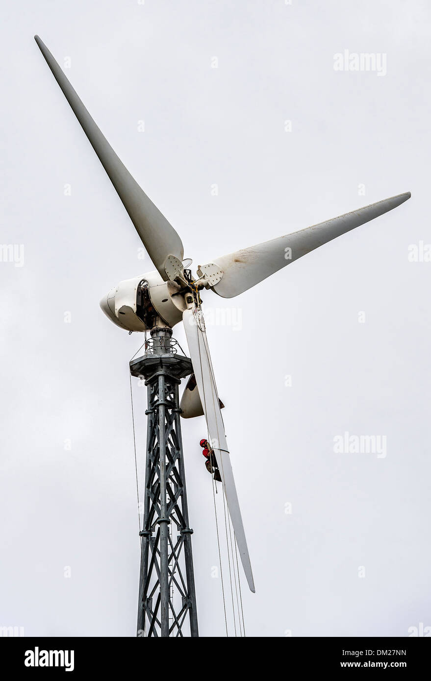 L'homme la réparation de l'hélice d'une éolienne. Banque D'Images