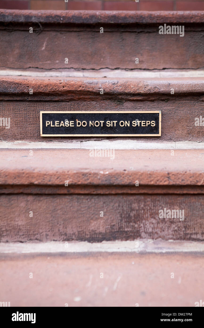 Un panneau avertit les gens de ne pas s'asseoir sur les marches. Banque D'Images