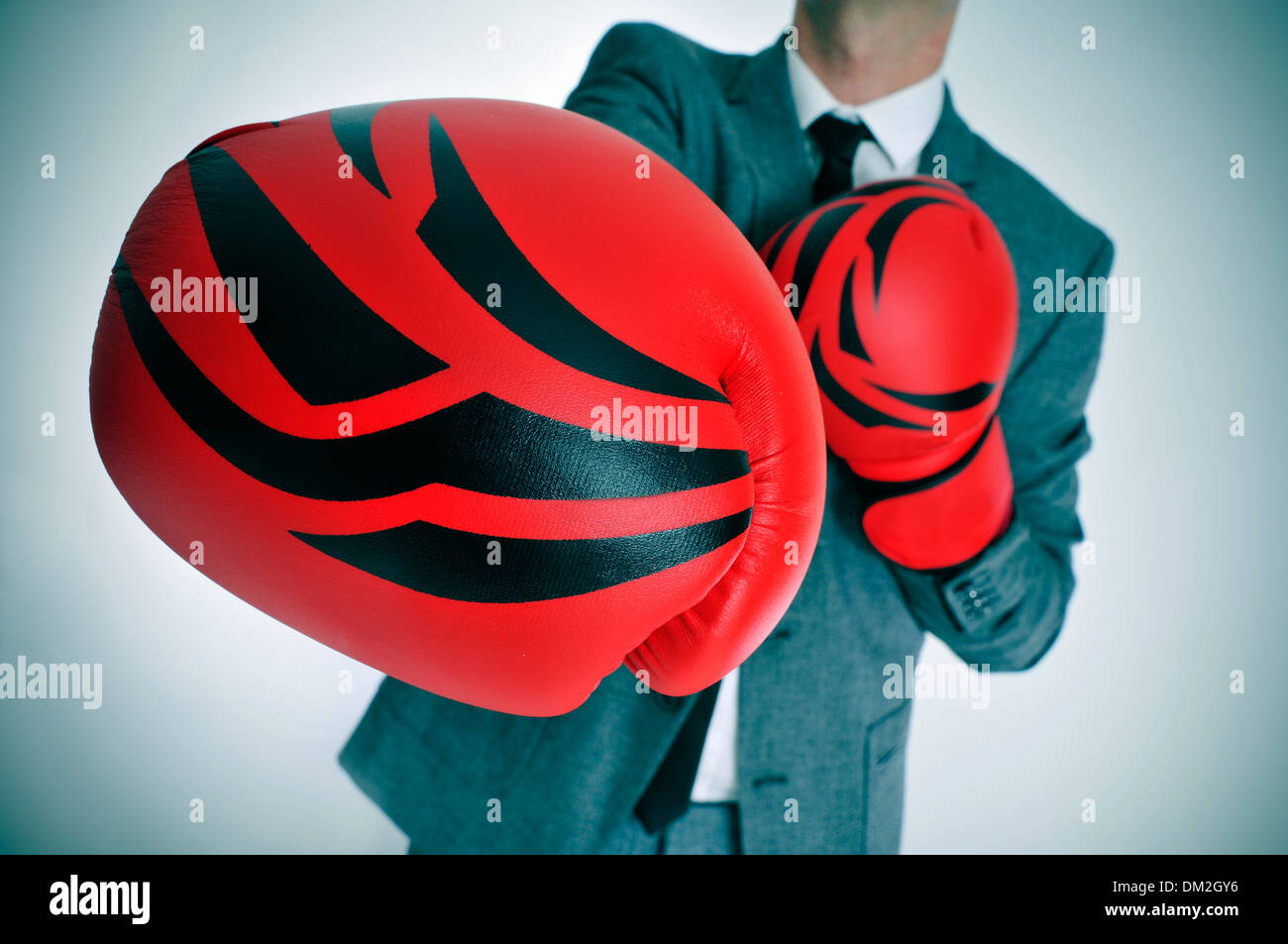 Un homme portant un costume avec des gants de boxe de jeter un coup de poing Banque D'Images