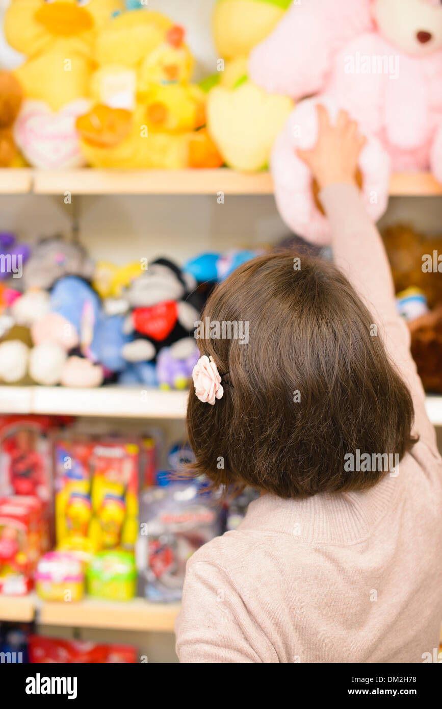 Young Woman picking des jouets dans un magasin Banque D'Images