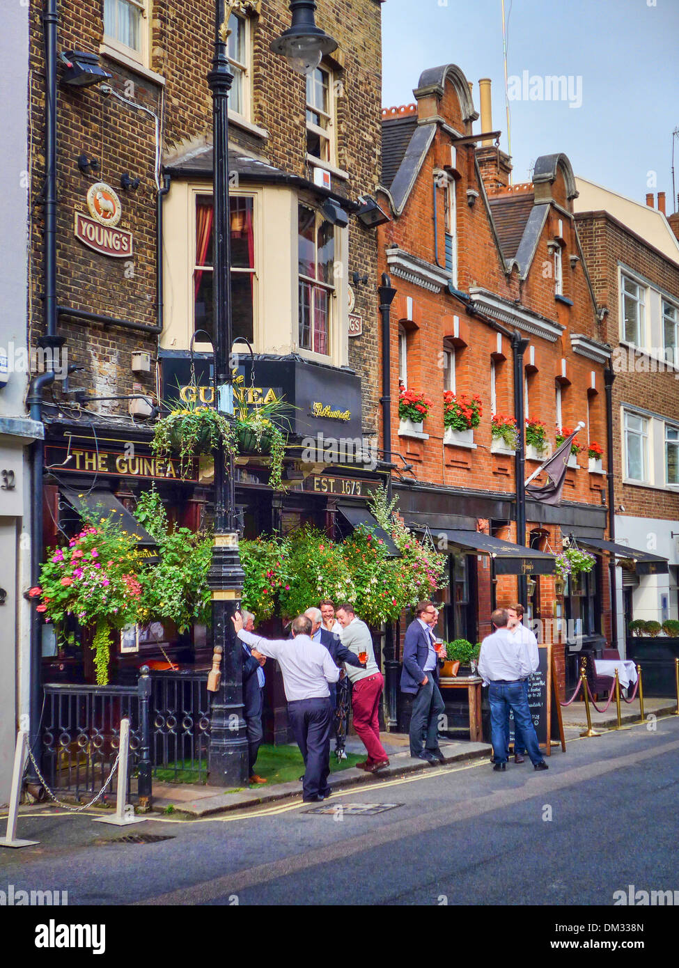 Pause à l'extérieur de la Guinée Restaurant à Londres UK Banque D'Images