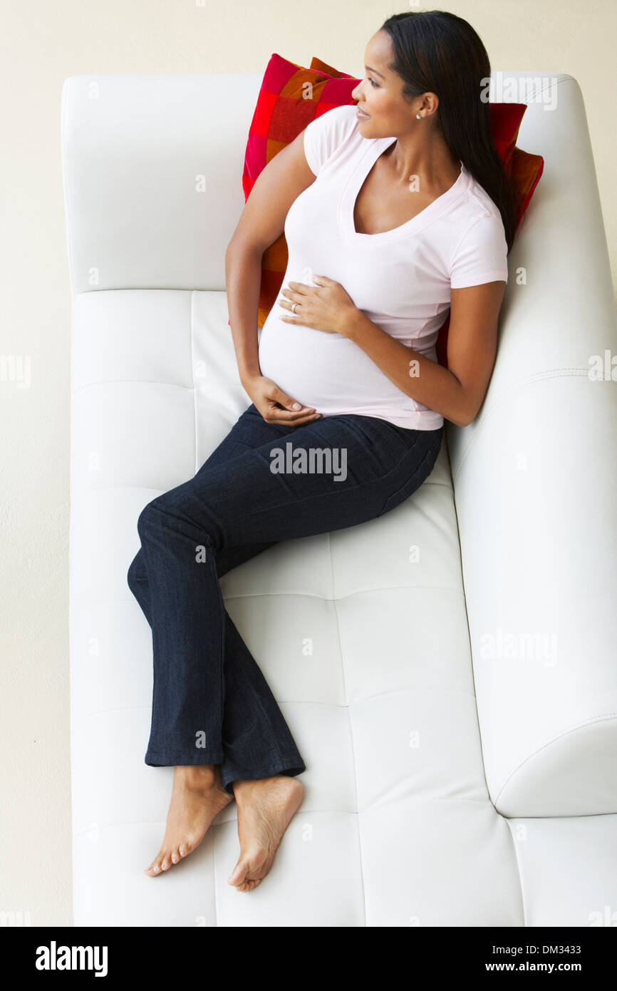 Vue de dessus de femme enceinte Relaxing On Sofa Banque D'Images Vue de dessus de femme enceinte Relaxing On Sofa Banque D'Images