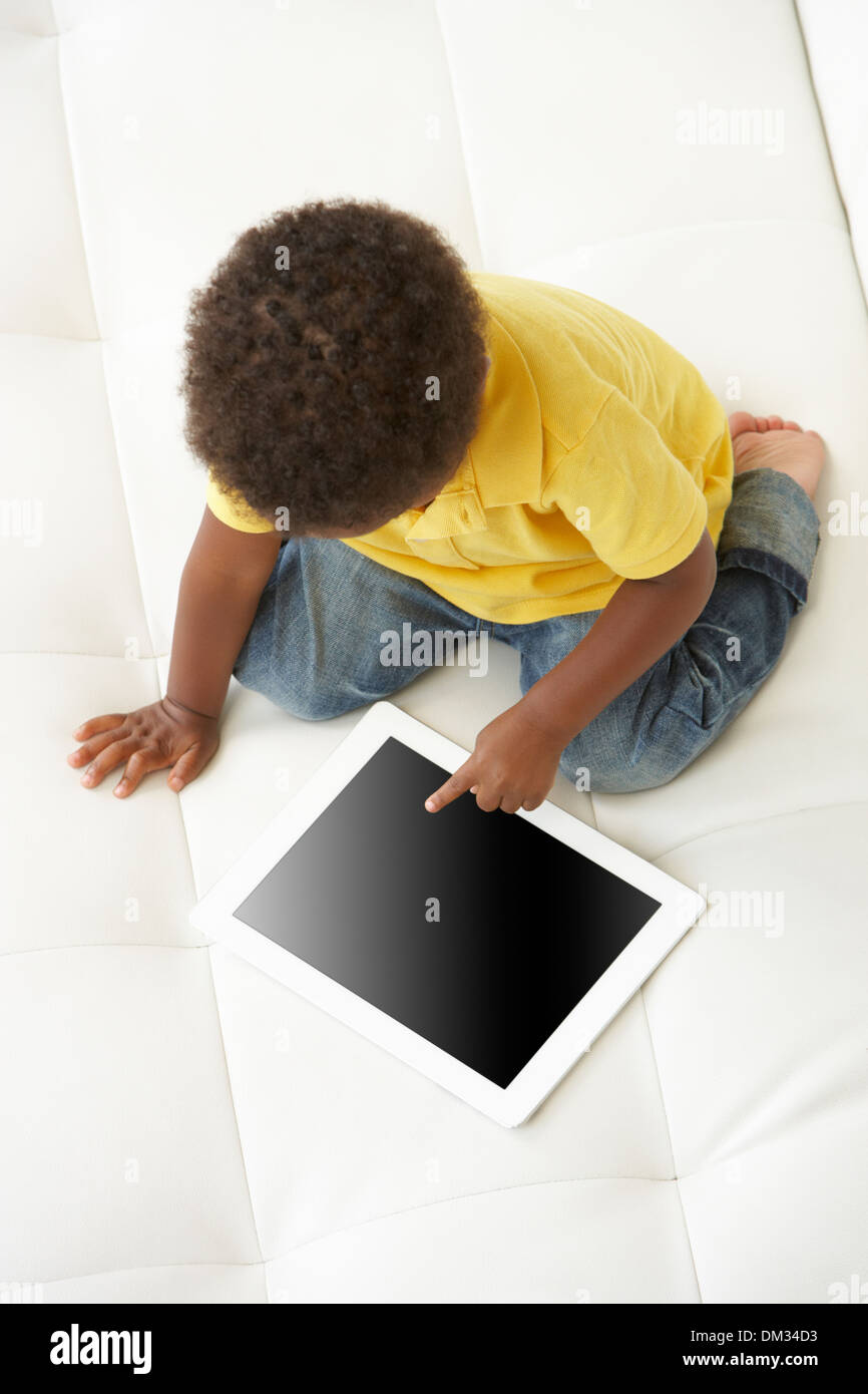 Vue de dessus de garçon sur le canapé à jouer avec Digital Tablet Banque D'Images Vue de dessus de garçon sur le canapé à jouer avec Digital Tablet Banque D'Images