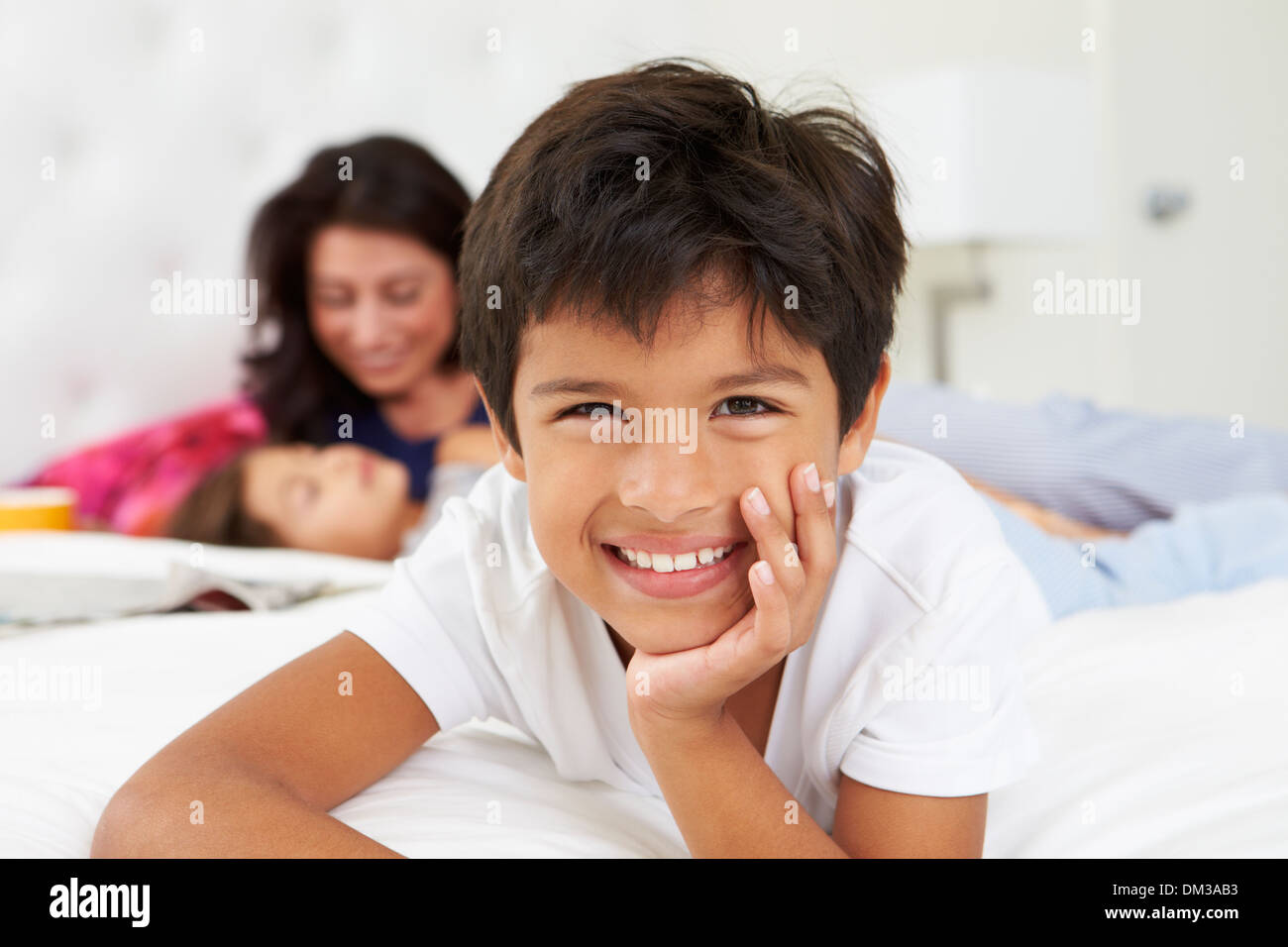 Mère et enfants Relaxing In Bed Wearing pajamas Banque D'Images