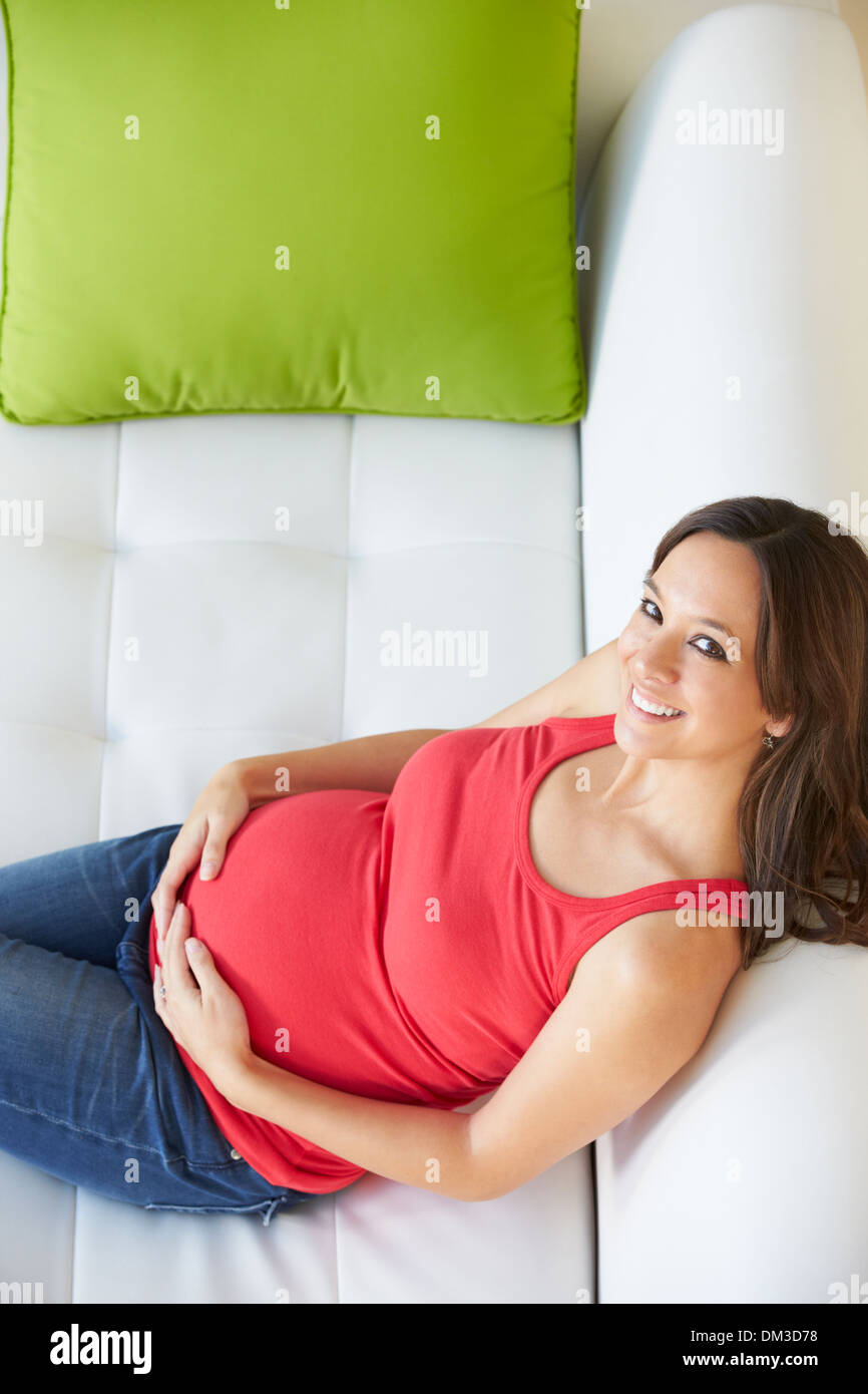 Vue de dessus de femme enceinte Relaxing On Sofa Banque D'Images Vue de dessus de femme enceinte Relaxing On Sofa Banque D'Images