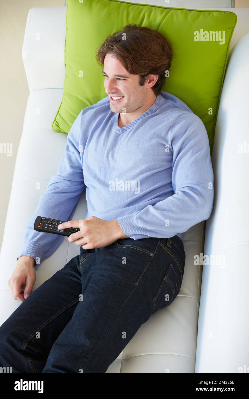 Vue aérienne de Man Relaxing On Sofa Watching Television Banque D'Images Vue aérienne de Man Relaxing On Sofa Watching Television Banque D'Images