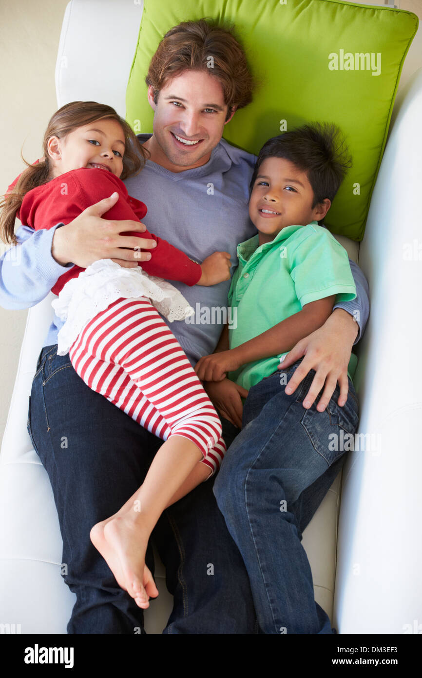 Vue de dessus de père et enfants Relaxing On Sofa Banque D'Images Vue de dessus de père et enfants Relaxing On Sofa Banque D'Images