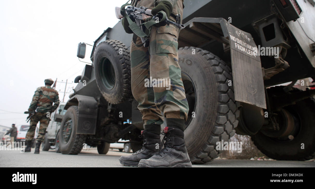 Srinagar, au Cachemire 11 décembre 2013. Les forces militaires indiens montent la garde devant le sang de leurs camarades après militants présumés tués un Indien paramilitaire et blessé un autre dans la banlieue de Srinagar. Des militants présumés tués abattu un policier indien et blessé un autre de façon critique lorsqu'ils ont tiré sur les soldats, à bout portant sur la route de Srinagar périphérie. (Sofi Suhail/ Alamy Live News) Banque D'Images