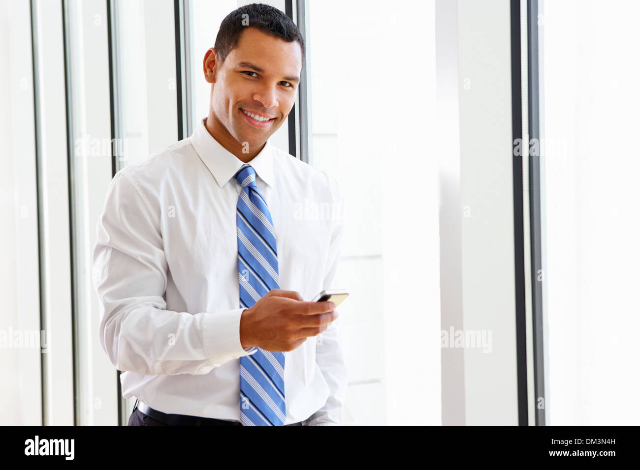 Businessman Using Mobile Phone In Office Banque D'Images