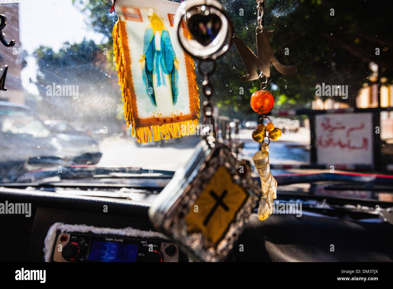 Vierge Marie et d'autres parures chrétienne sur la voiture d'un chauffeur de taxi Copte égyptienne. Sohag, Egypte Banque D'Images