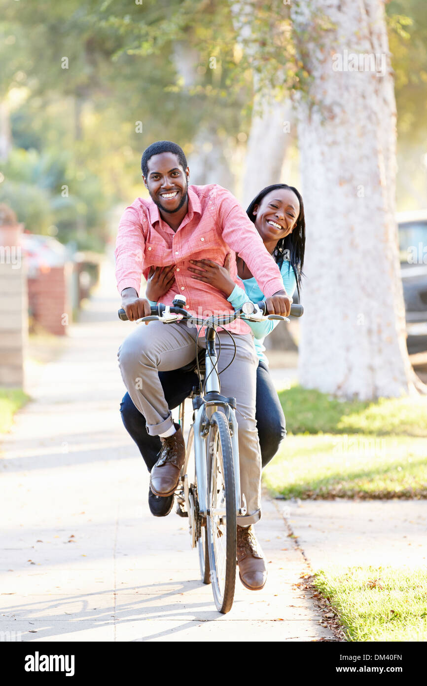 Couple à vélo le long de la rue de banlieue ensemble Banque D'Images