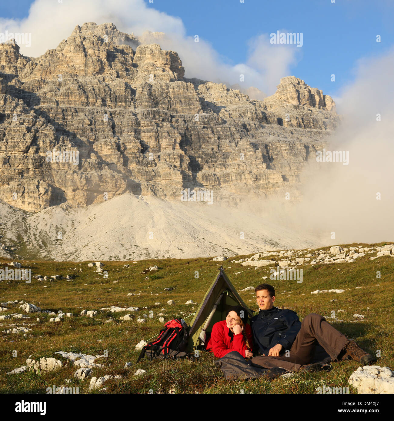 Les jeunes camping dans les montagnes en face d'un paysage spectaculaire Banque D'Images