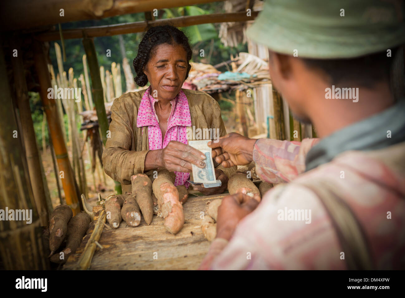 Homme de racines de manioc à l'achat d'un marché à Fenerive Est, à Madagascar. Banque D'Images