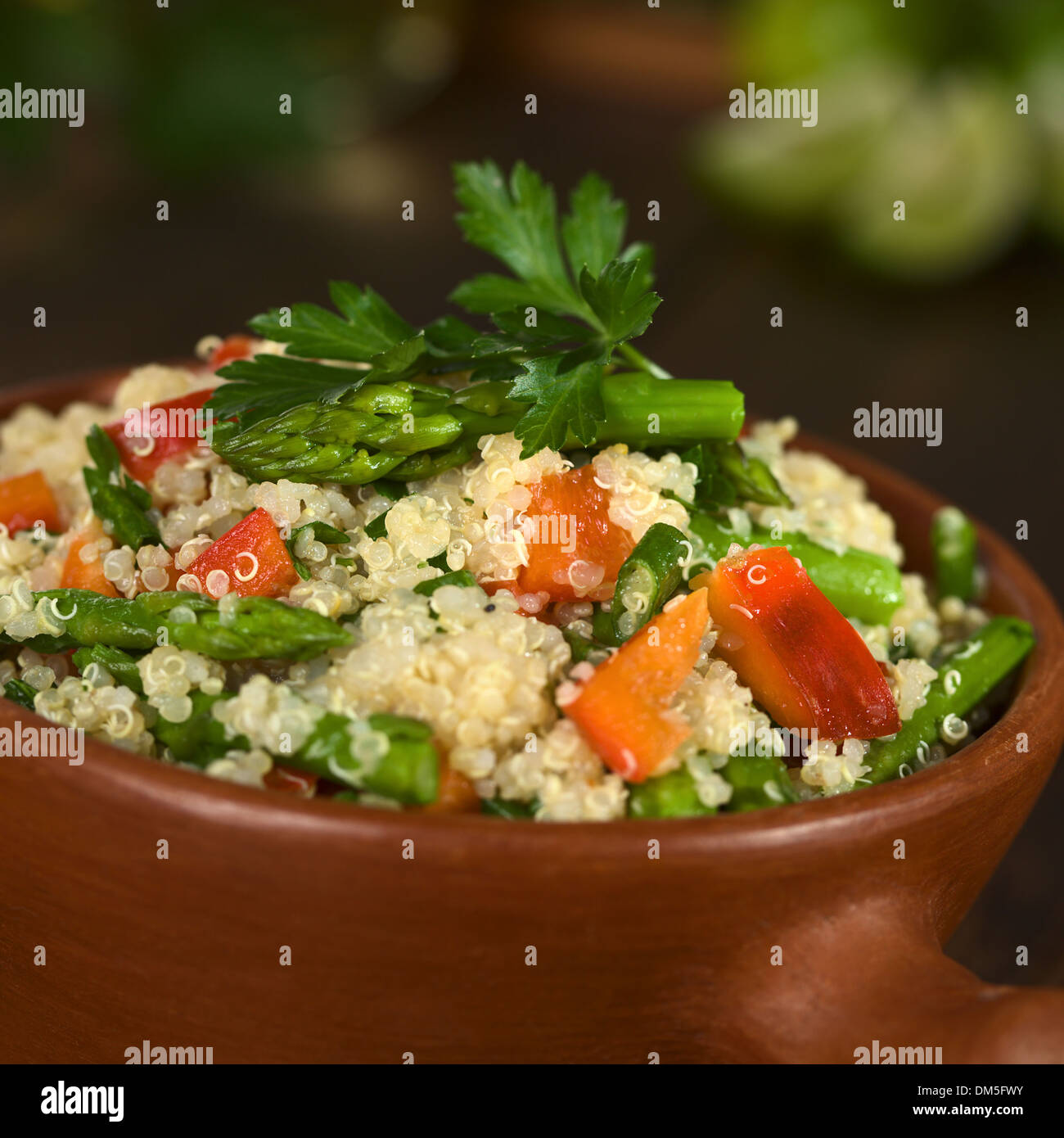 Le quinoa végétarien plat d'asperges vertes et poivron rouge, saupoudrée de persil dans le bol rustique Banque D'Images