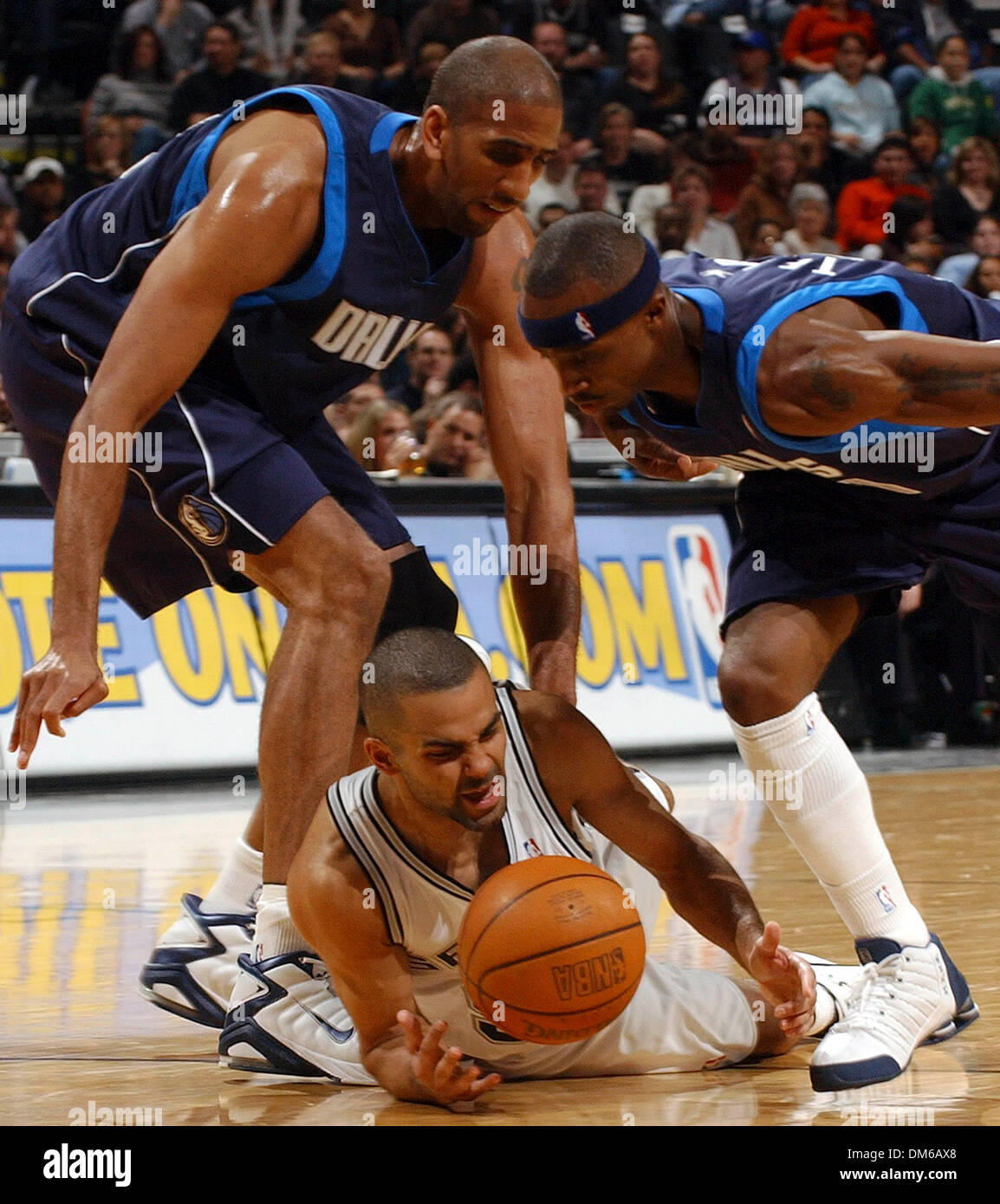 Jan 14, 2005 ; San Antonio, TX, USA ; des Spurs Tony Parker hits le plancher tout en passant pour une balle lâche entre Mavericks' Calvin Booth(à gauche) et Jason Terry Vendredi 14 janvier 2005, à la SBC Center. Banque D'Images