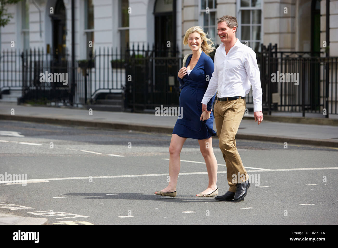 Couple avec femme enceinte Crossing City Road Banque D'Images
