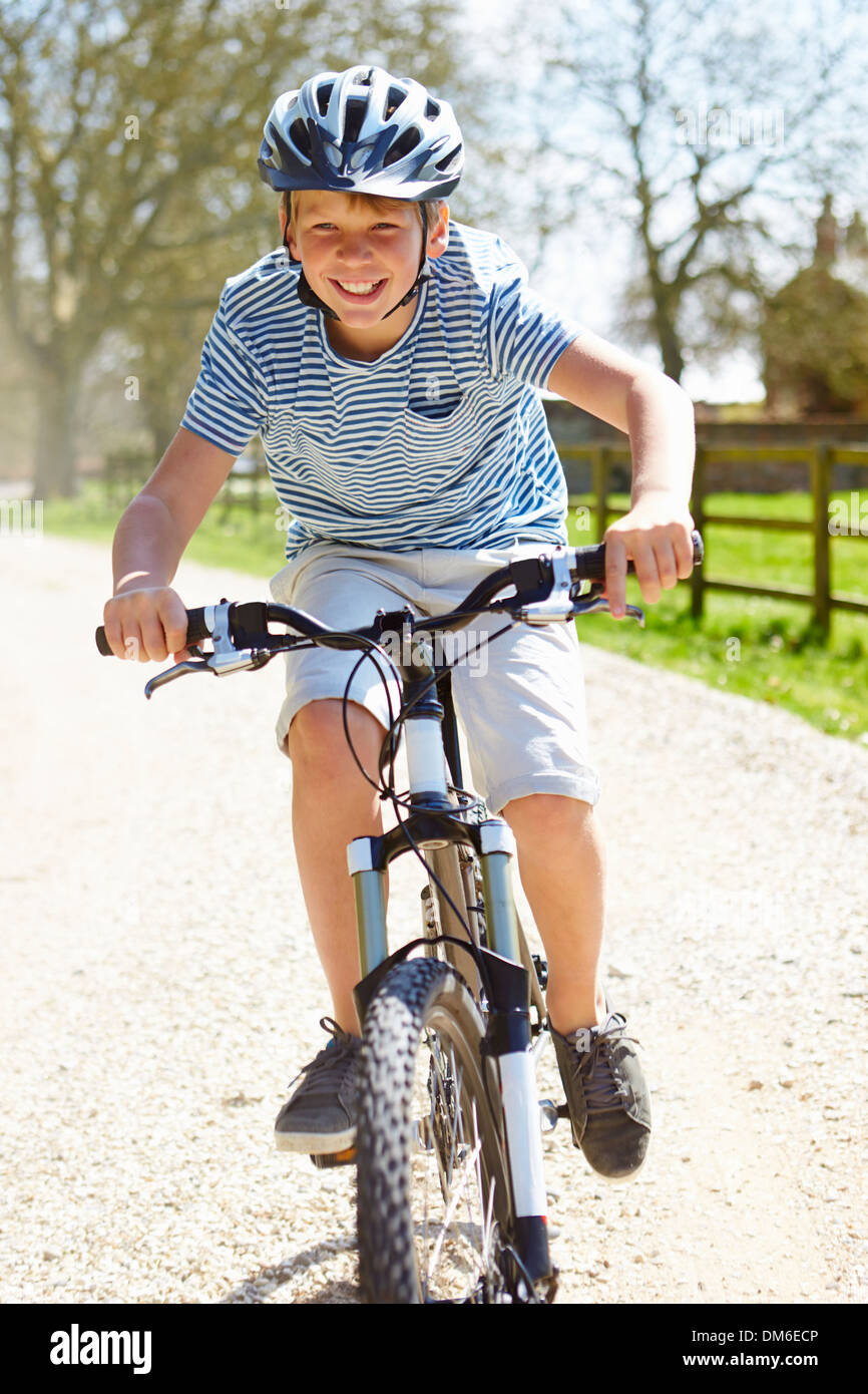 Young Boy Riding Bike le long de la voie de Pays Banque D'Images