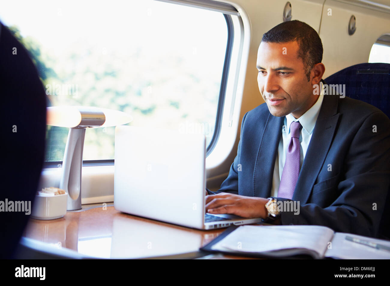 D'affaires pour se rendre à son travail sur le Train and Using Laptop Banque D'Images