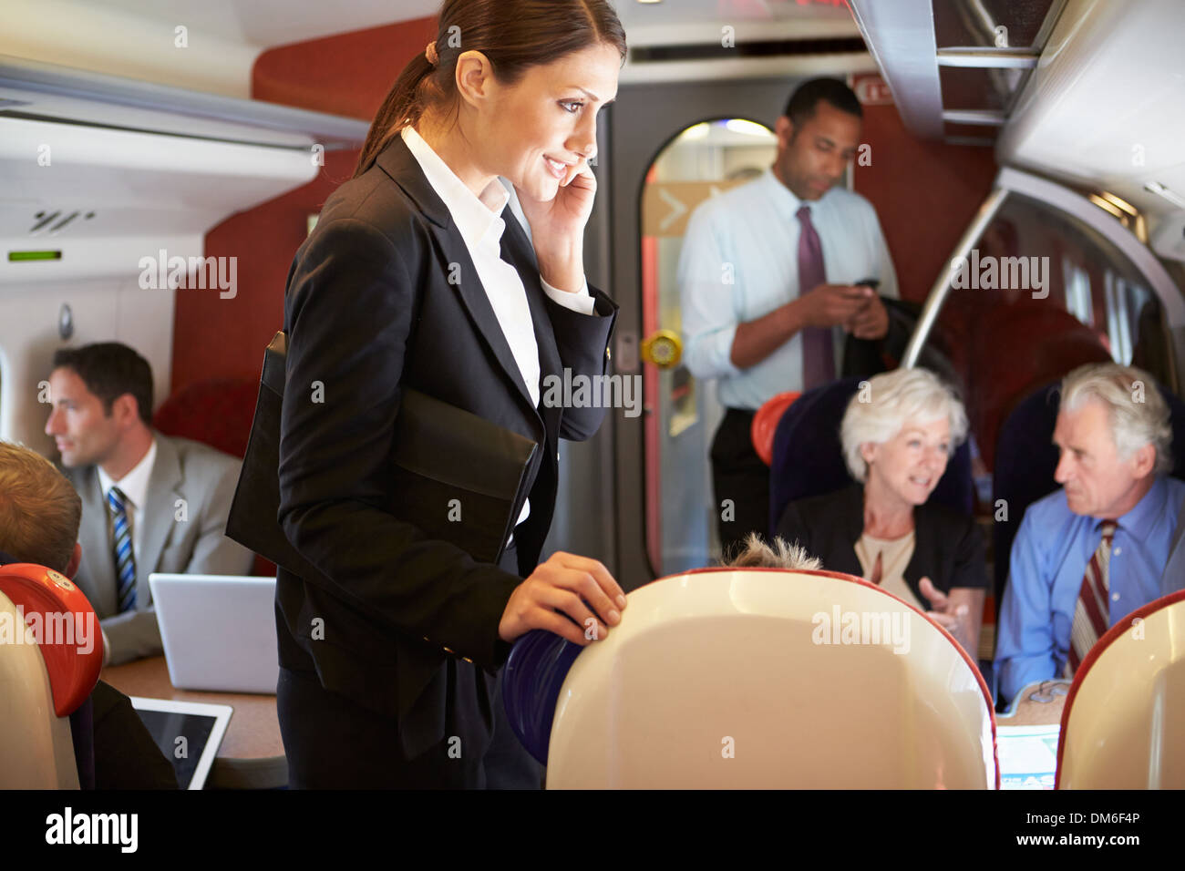 Businesswoman Using Mobile Phone On occupé Commuter Train Banque D'Images