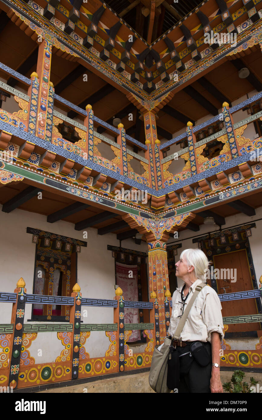 Le Bhoutan, la vallée de Bumthang, senior femme occidentale en cour couvent en bois peint. Banque D'Images