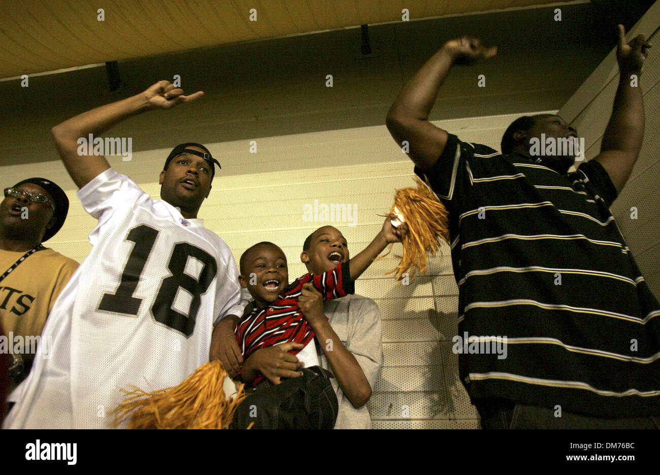 Oct 02, 2005 ; San Antonio, TX, USA ; NFL football : San Antonio résident, Tommy Doster, de gauche, cheers avec Katrina évacués de la Nouvelle-Orléans, y compris Joe Preston, Franklin Foley, 12, tenant son frère, Derrick Jones Jr., 4, et leur père, Derrick Jones, après la Nouvelle Orleans Saints intercepté contre les Bills de Buffalo à l'Alamodome de San Antonio. Les personnes évacuées sont livi Banque D'Images