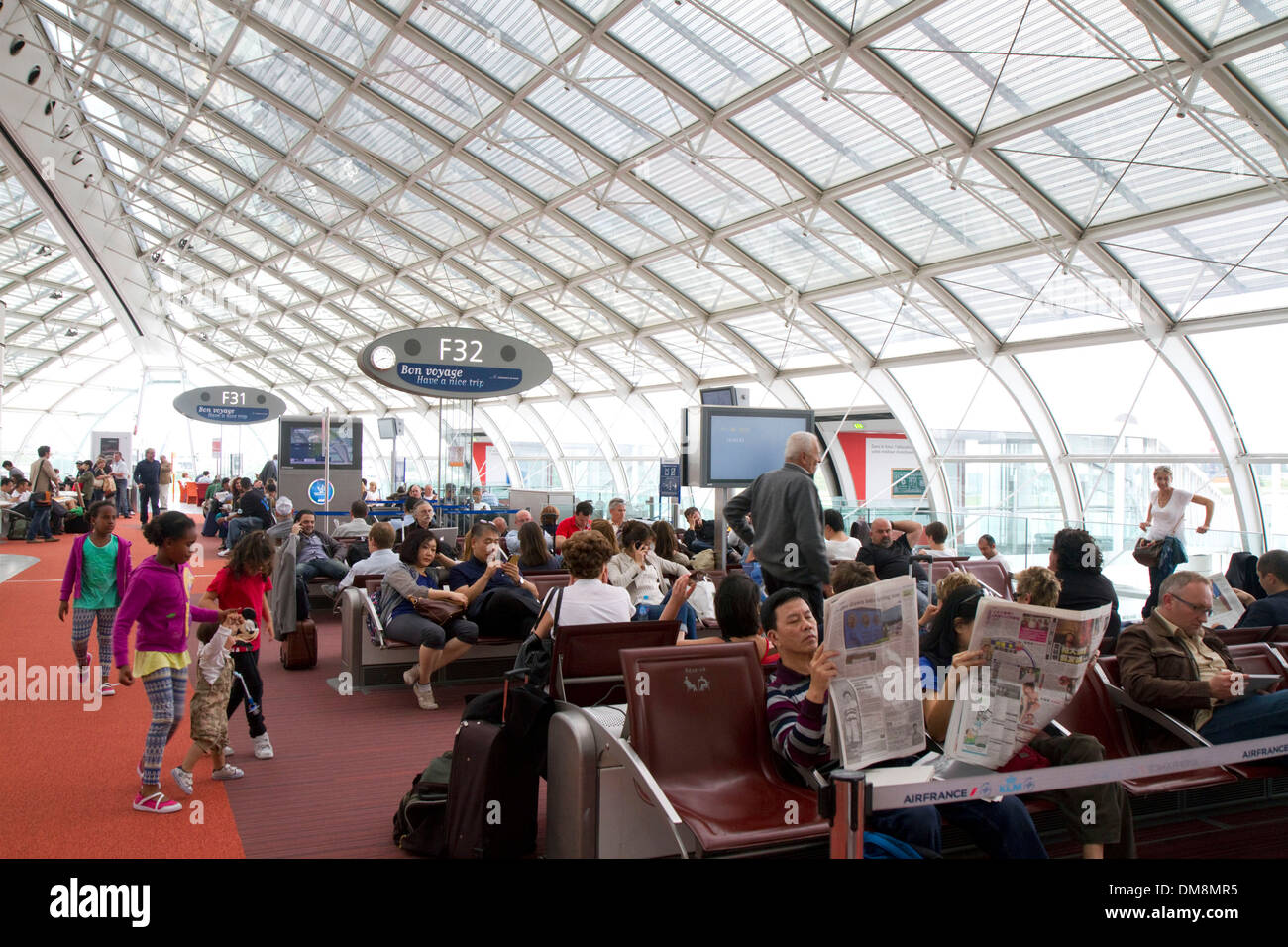 Les voyageurs dans une salle d'attente à l'aéroport Charles de Gaulle, Paris, France. Banque D'Images