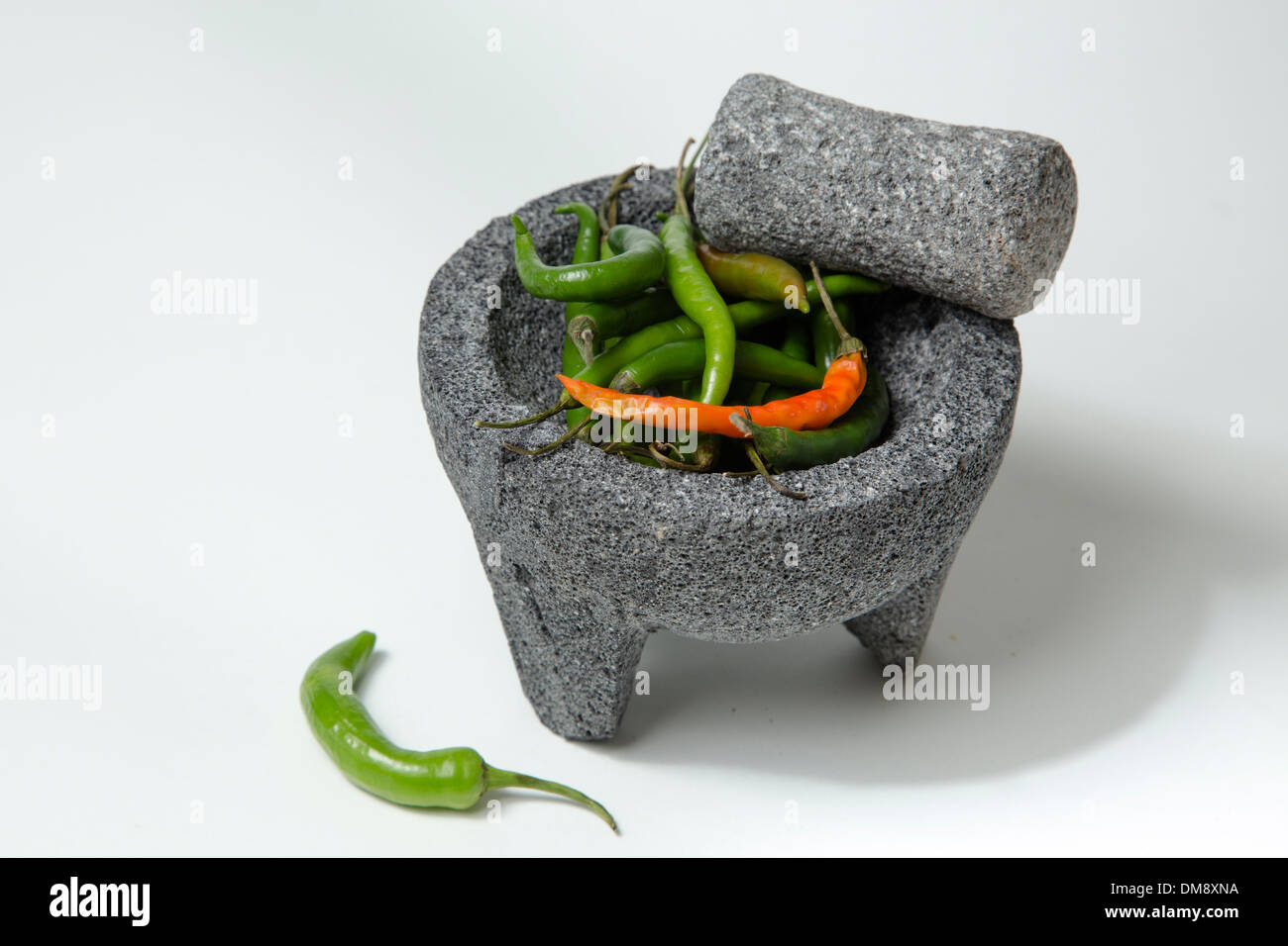 Les poivrons avec un pilon Mortier en pierre Banque D'Images