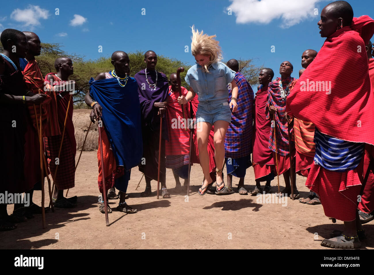 Une jeune danse touristique avec les guerriers Masaï dans la zone de conservation de Ngorongoro Crater Highlands de Tanzanie en Afrique Banque D'Images