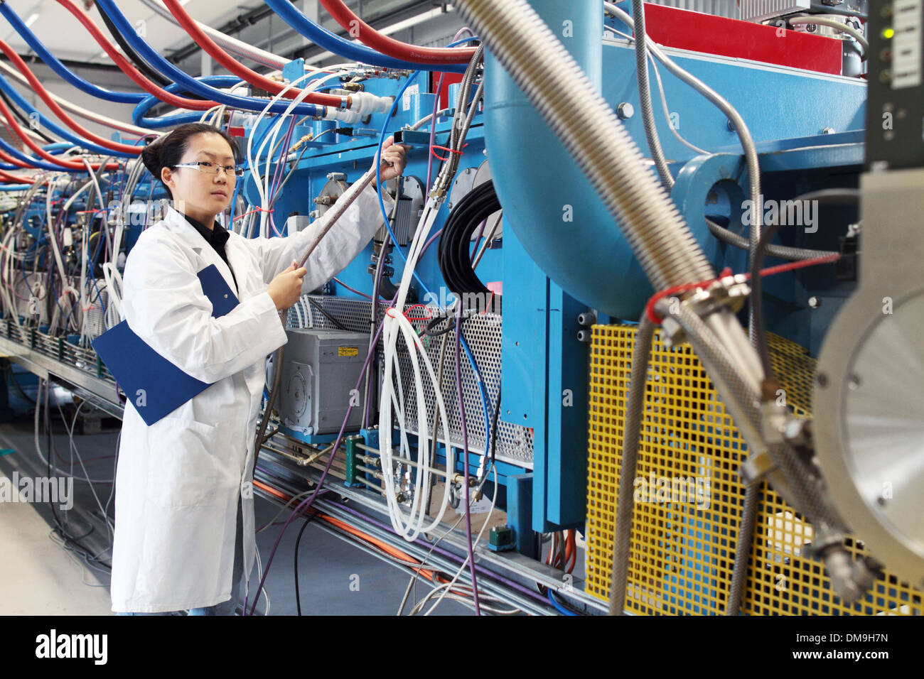 L'Asie une femme scientifique travaillant dans un laboratoire avec une blouse de laboratoire contrôle une machine Banque D'Images