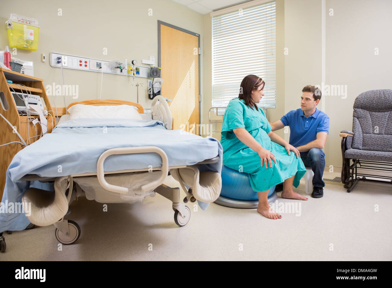 L'homme à la femme enceinte à sur Boule d'exercice à l'hôpital Banque D'Images