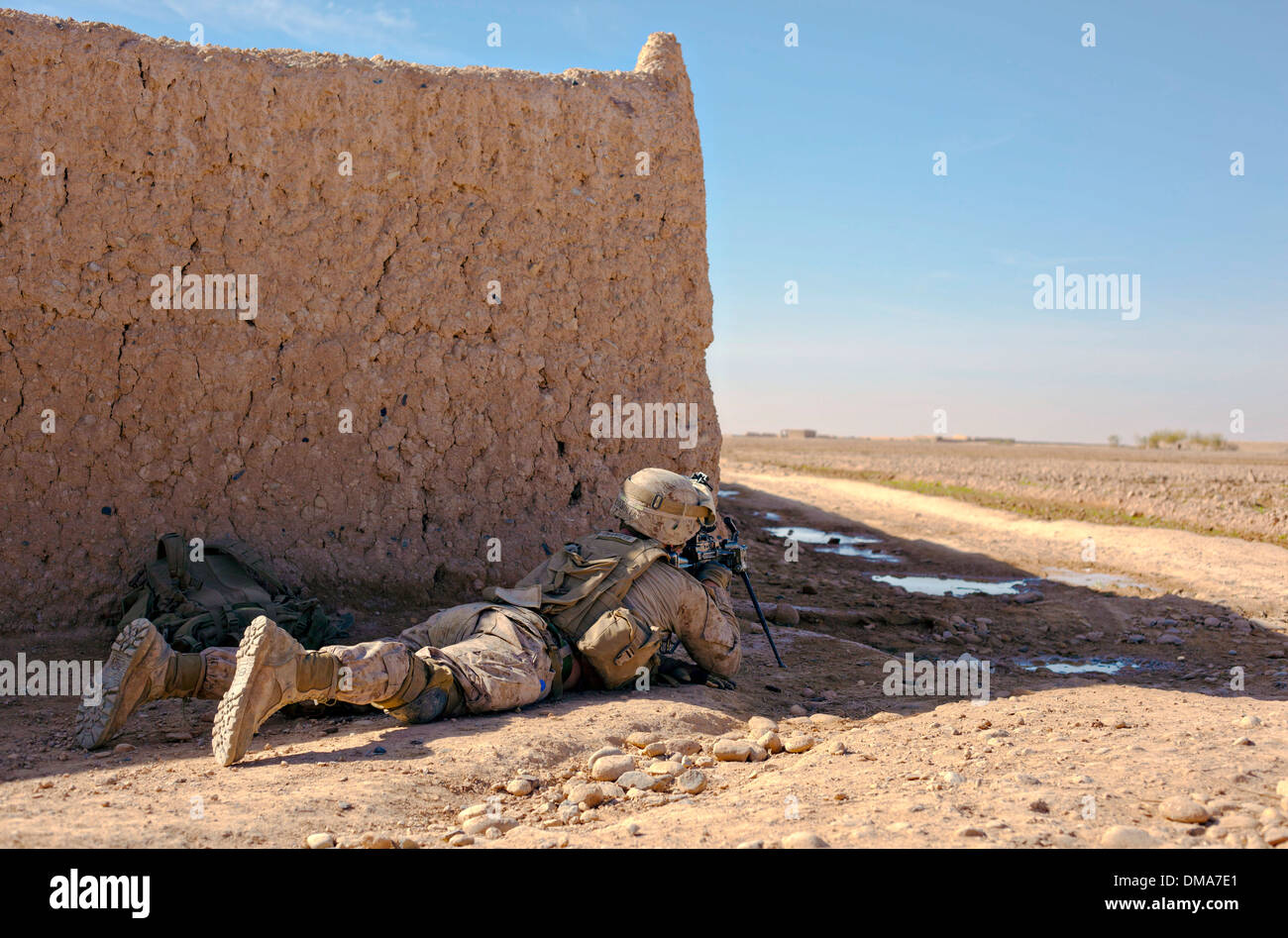 Un Marine américain couvre un champ ouvert avec une mitrailleuse M249 au cours d'une fusillade avec des insurgés le 4 décembre 2013 près de la Gul Bari dans le bazar du district de Nad Ali, dans la province d'Helmand, en Afghanistan. Banque D'Images