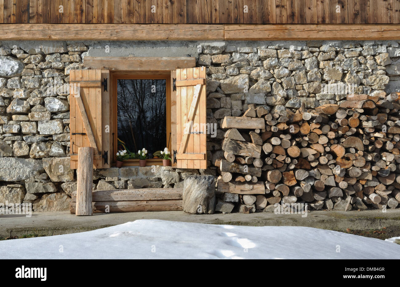Gîte en pierre et bois avec des tas de bois de chauffage Banque D'Images